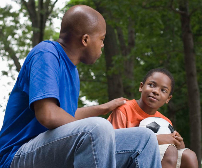 African-American father talking with son