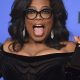Oprah Winfrey holding up Golden Globe award